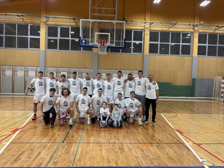 Fotografija igralcev in vodstva ekipe takoj po zmagi. Peter Kaluža ima v naročju hčerko Loro, ob njej nečak Val, oba trenirata pri KK Pivka perutninarstvo